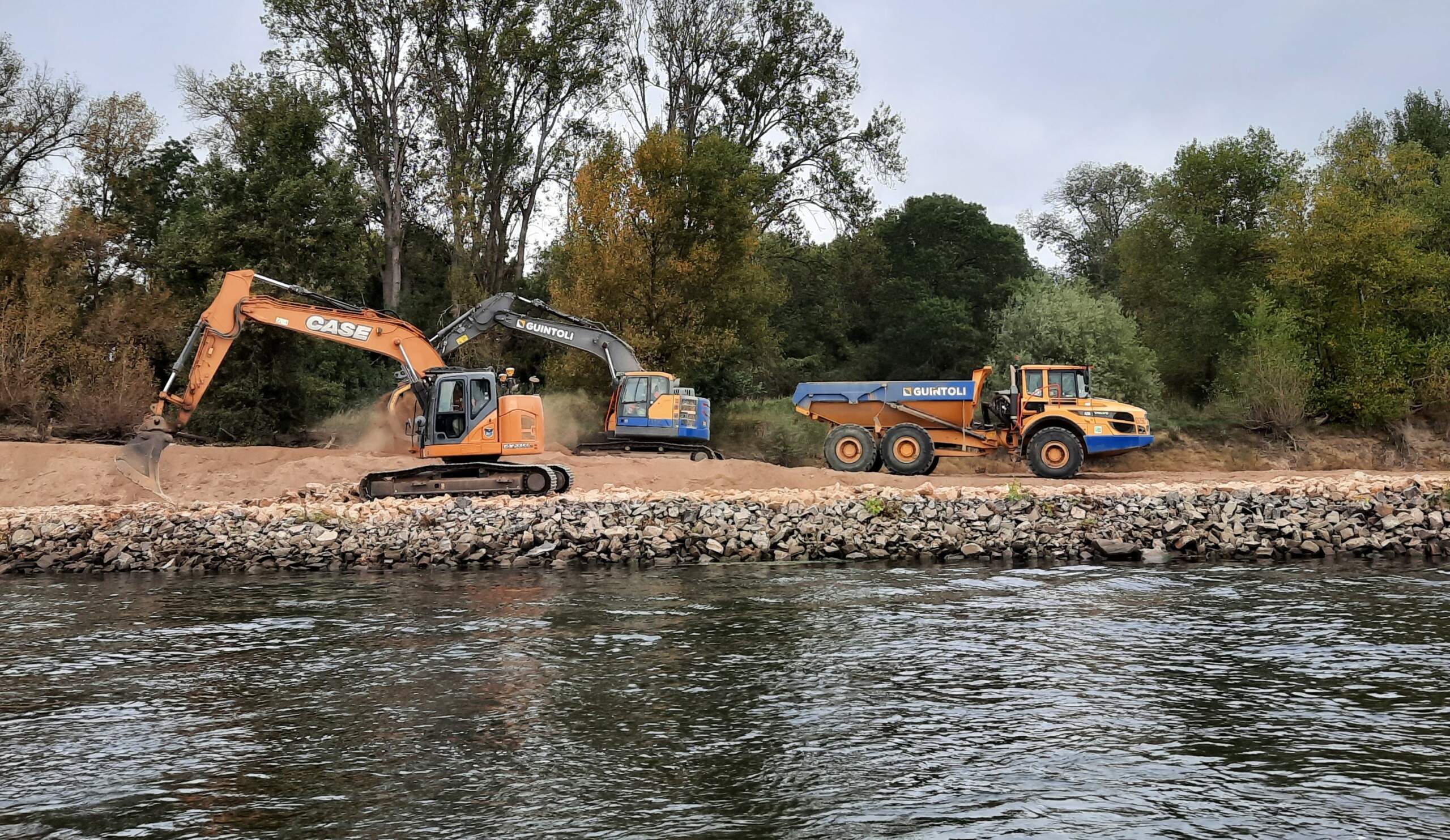 Pelle remodelant un épi et tombereau transportant les matériaux